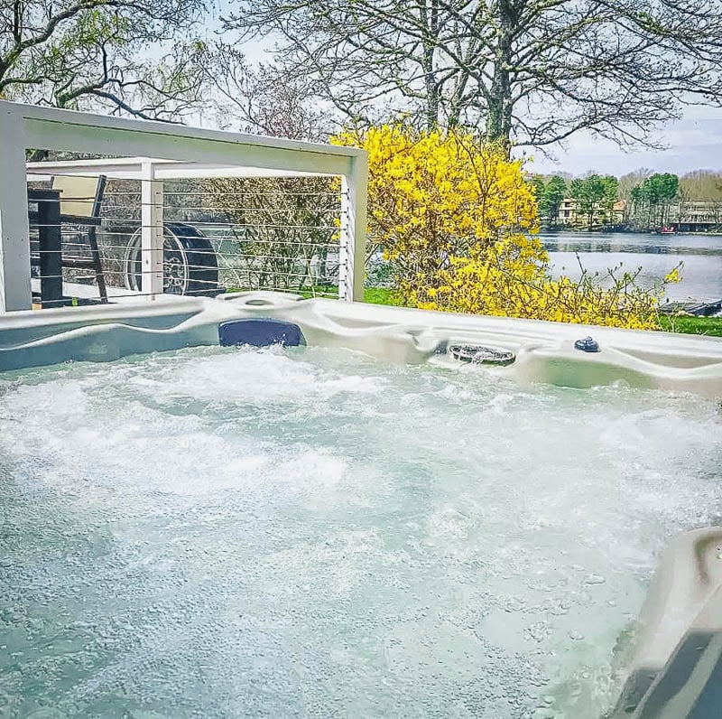 This lake house rental in New England has its own private hot tub