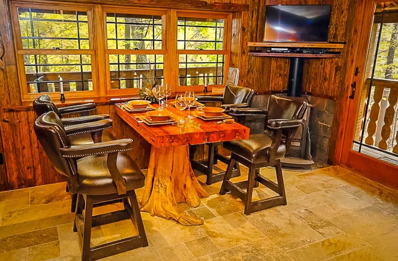 Cozy dining table made from a tree stump inside these New England cabins