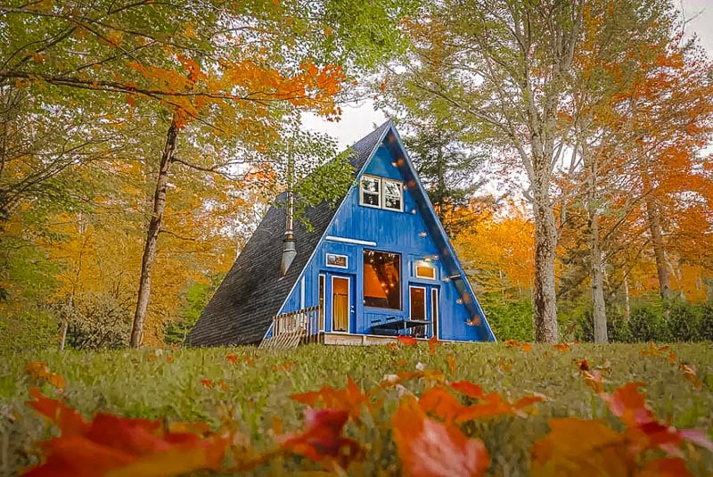 A-Frame cabin rental in the US surrounded by fall foliage.