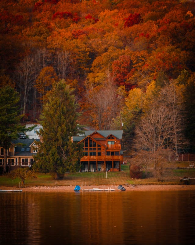 A cabin on Deep Creek Lake surrounded by fall foliage.