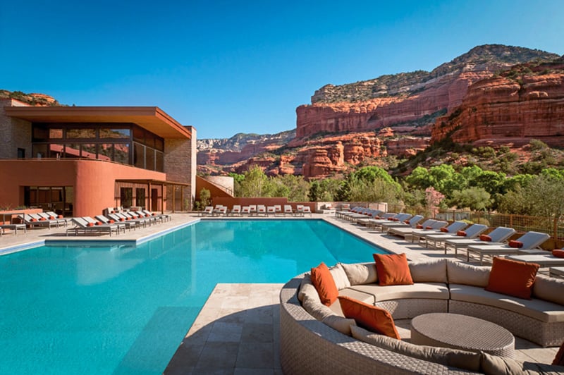 View of resort's pool, deck, restaurant, and tennis courts with Arizona red rock formations in the background.